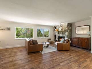 Experience cozy living in this inviting living room, featuring a stunning stone fireplace perfect for chilly evenings.