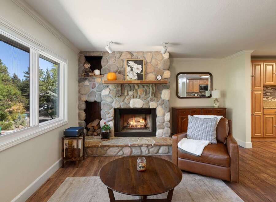 Cozy up by the stunning stone fireplace, a true centerpiece of this inviting living room.