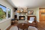 Cozy up by the stunning stone fireplace, a true centerpiece of this inviting living room.