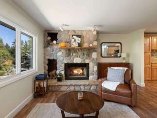 Cozy up by the stunning stone fireplace, a true centerpiece of this inviting living room.