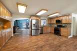 Discover this spacious kitchen featuring warm wood cabinetry, granite countertops, and a sleek stainless steel refrigerator.
