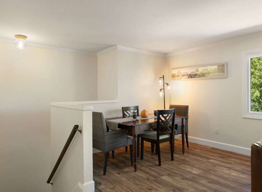 This dining area features a warm wooden table surrounded by comfortable upholstered chairs, perfect for intimate meals.