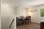 This dining area features a warm wooden table surrounded by comfortable upholstered chairs, perfect for intimate meals.
