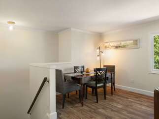 This dining area features a warm wooden table surrounded by comfortable upholstered chairs, perfect for intimate meals.