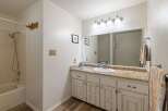This charming bathroom features a bathtub/shower combo with tiled walls and a chrome showerhead.