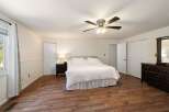 This spacious bedroom features a comfortable king-sized bed with a white quilted comforter, perfect for relaxation.