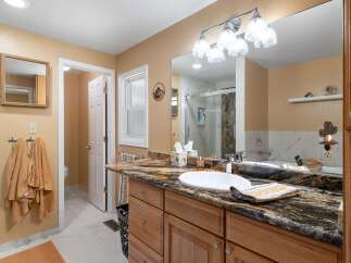 Step into this beautifully updated bathroom featuring a spacious vanity with a granite countertop and a large undermount sink.