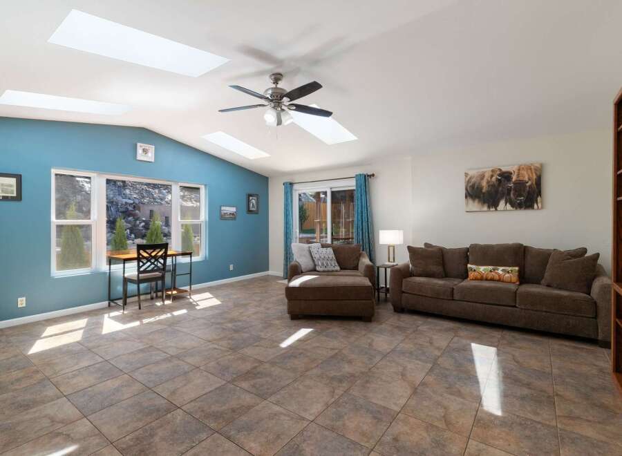 Experience abundant natural light in this spacious living area, enhanced by multiple skylights and large windows offering scenic views.