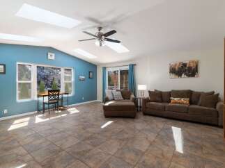 Experience abundant natural light in this spacious living area, enhanced by multiple skylights and large windows offering scenic views.