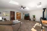 This spacious living area boasts vaulted ceilings with multiple skylights, flooding the room with natural light.