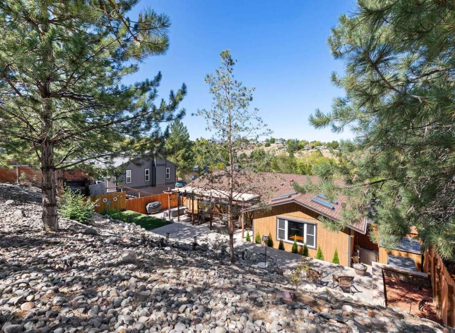 Discover this charming home nestled amidst mature pine trees, offering a serene and private backyard oasis.