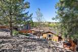Discover this charming home nestled amidst mature pine trees, offering a serene and private backyard oasis.
