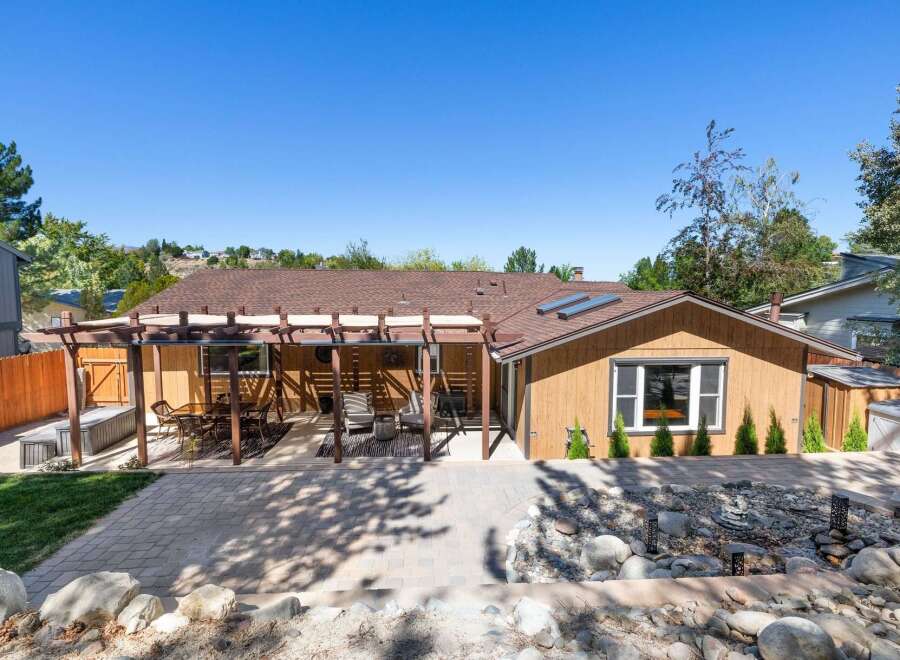 Enjoy outdoor living with this charming home featuring a spacious pergola-covered patio perfect for entertaining.