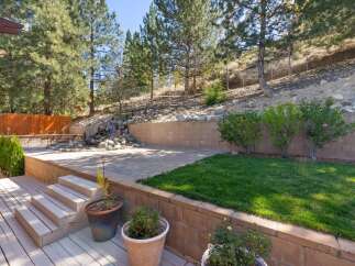 Discover this stunning backyard oasis featuring a multi-level design with a spacious deck and a charming patio area.