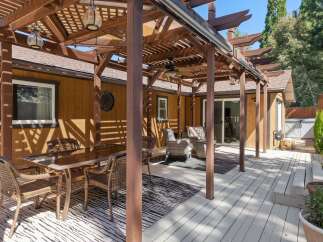 Enjoy outdoor living with this spacious deck featuring a covered pergola, perfect for al fresco dining and relaxation.