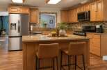 This spacious kitchen boasts beautiful light wood cabinetry and granite countertops, offering ample storage and workspace.
