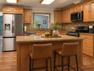 This spacious kitchen boasts beautiful light wood cabinetry and granite countertops, offering ample storage and workspace.