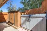 Enhance your outdoor storage with this practical setup, featuring a tall wooden shed and a complementary grey storage unit.