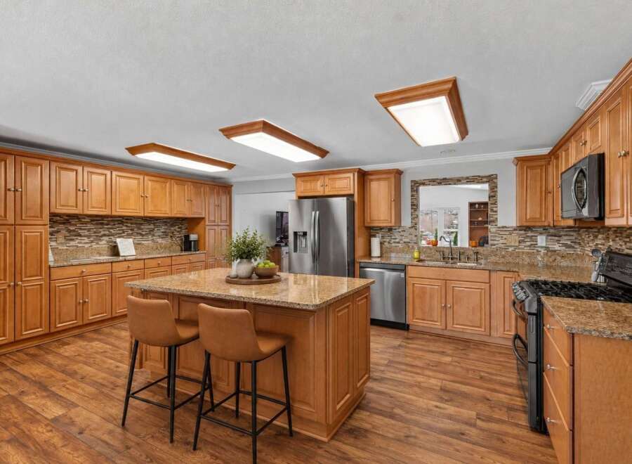 Step into this beautifully updated kitchen, featuring warm cherry wood cabinets and granite countertops that exude elegance.