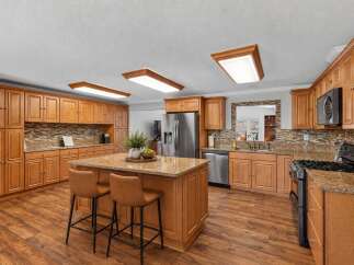 Step into this beautifully updated kitchen, featuring warm cherry wood cabinets and granite countertops that exude elegance.