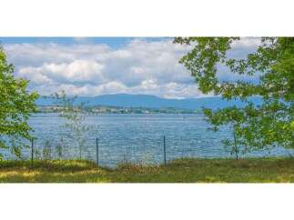 Experience serene lakeside living with this stunning property offering breathtaking views of the water and distant mountains.