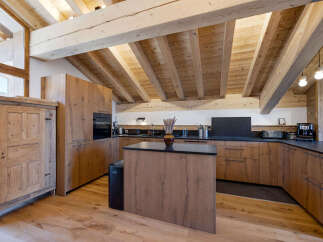 Experience rustic charm in this mountain kitchen featuring exposed wooden beams and a vaulted ceiling.