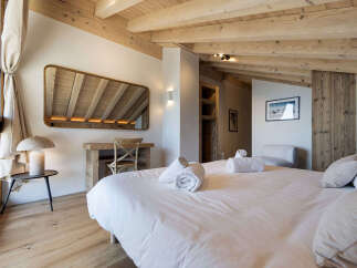 Experience rustic charm and modern comfort in this beautifully appointed bedroom, featuring exposed wooden beams and a cozy, inviting atmosphere.