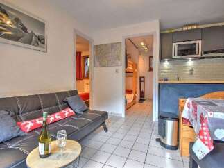 This charming apartment features a comfortable living area with a sofa and a coffee table, perfect for relaxing after a day of skiing.