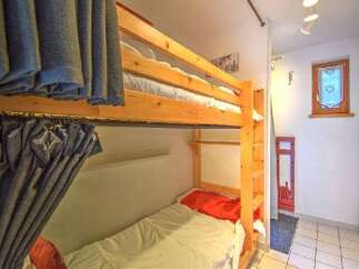 This cozy room features a sturdy wooden bunk bed, perfect for maximizing space in a vacation rental or children's room.