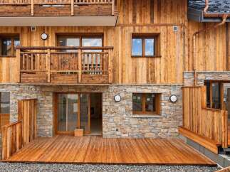 Experience modern alpine living in this stunning property featuring natural wood siding and a stone base.
