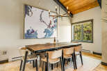 Experience elegant dining in this spacious room, featuring a large wooden table with seating for six and a striking abstract map artwork.