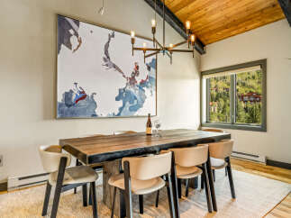 Experience elegant dining in this spacious room, featuring a large wooden table with seating for six and a striking abstract map artwork.