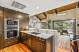 Experience modern living in this stunning kitchen featuring sleek, dark wood cabinetry and a built-in stainless steel oven and microwave.