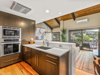 Experience modern living in this stunning kitchen featuring sleek, dark wood cabinetry and a built-in stainless steel oven and microwave.