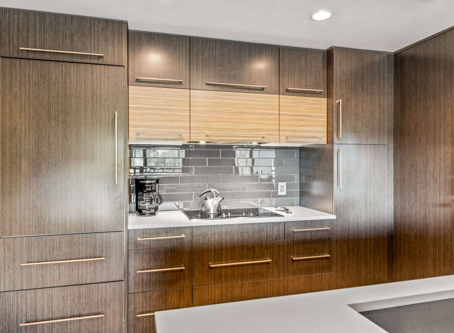 Experience modern luxury in this stunning kitchen, featuring sleek, dark wood cabinetry with elegant rose gold hardware.