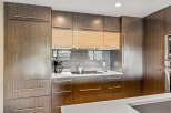 Experience modern luxury in this stunning kitchen, featuring sleek, dark wood cabinetry with elegant rose gold hardware.
