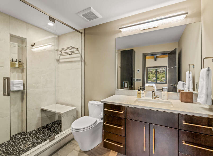 Experience modern luxury in this stunning bathroom, featuring a spacious walk-in shower with elegant tile work and a built-in bench.