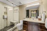 Experience modern luxury in this stunning bathroom, featuring a spacious walk-in shower with elegant tile work and a built-in bench.
