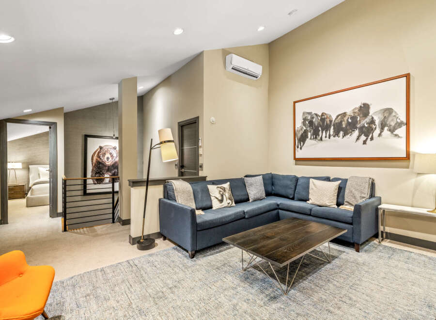 Experience modern mountain living in this spacious living area, featuring a comfortable sectional sofa perfect for gathering.