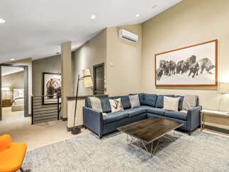 Experience modern mountain living in this spacious living area, featuring a comfortable sectional sofa perfect for gathering.