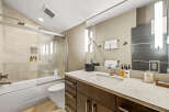 Experience modern luxury in this beautifully appointed bathroom, featuring a sleek bathtub and shower combination with elegant tilework.
