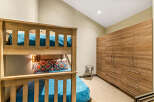 This bedroom features a charming wooden bunk bed with vibrant teal bedding and decorative pillows, perfect for accommodating guests.