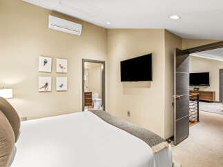 This bedroom offers a comfortable and modern retreat, featuring a plush bed adorned with decorative pillows and a cozy throw.