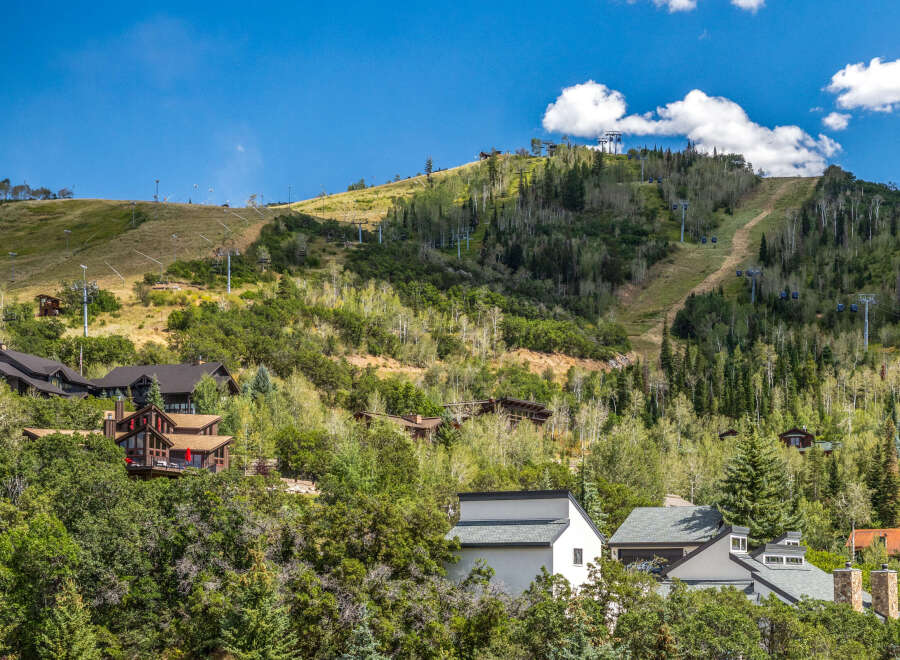 Nestled amidst lush greenery and towering trees, this stunning mountain property offers breathtaking views and a serene escape.