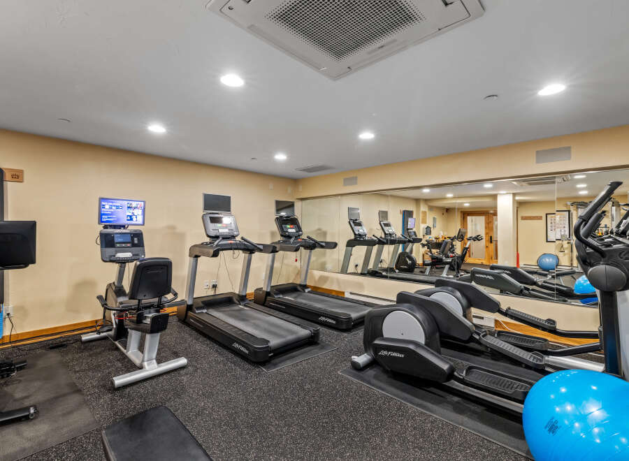 Stay active and energized in this well-equipped fitness center, featuring multiple treadmills, elliptical machines, and stationary bikes.