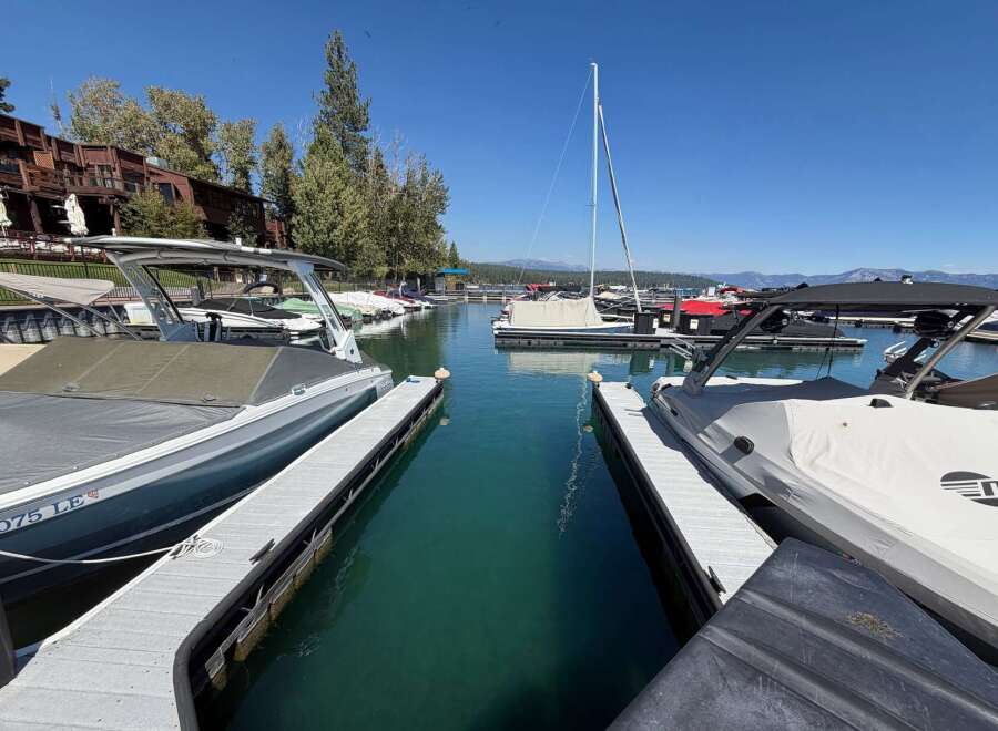Experience lakeside luxury with this stunning marina view, featuring a collection of sleek boats docked in crystal-clear turquoise waters.