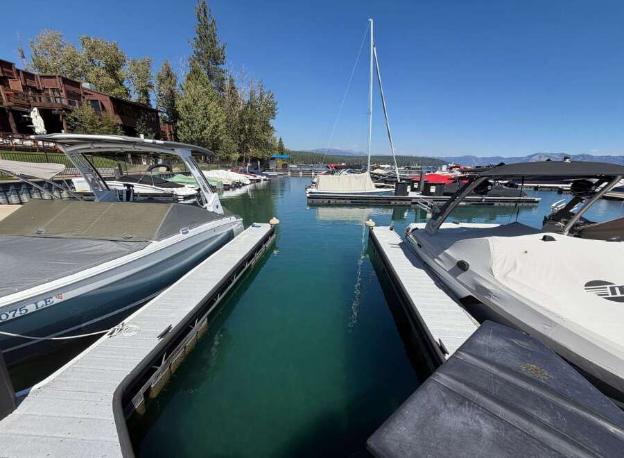 Experience lakeside luxury with this stunning marina view, featuring a collection of sleek boats docked in crystal-clear turquoise waters.