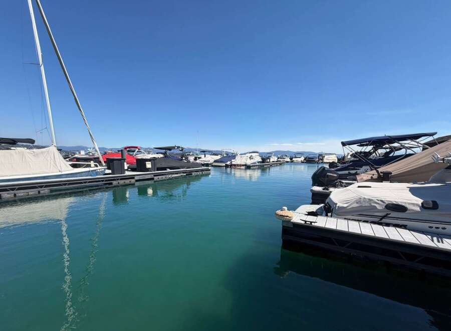 Experience the ultimate waterfront lifestyle with this stunning marina view, featuring a variety of boats docked under a clear blue sky.