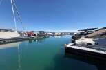 Experience the ultimate waterfront lifestyle with this stunning marina view, featuring a variety of boats docked under a clear blue sky.