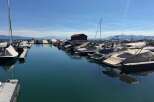 Experience waterfront living at its finest with this stunning marina view, featuring a collection of well-maintained boats docked under a clear blue sky.